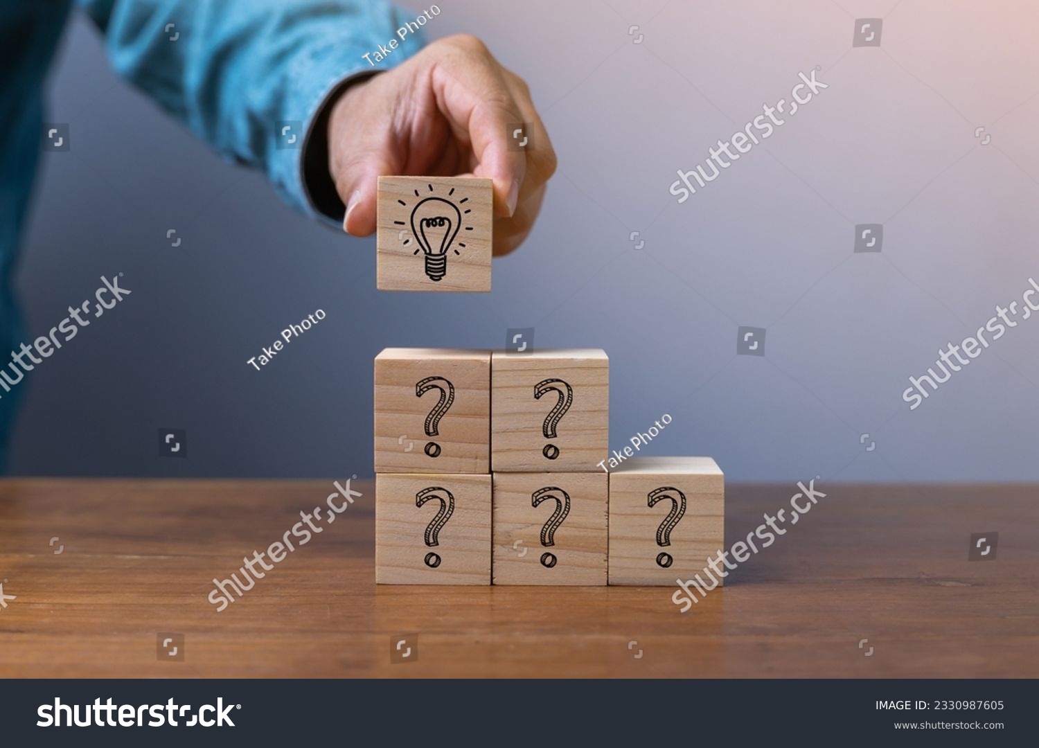 Hand putting wooden cube block stacking which print screen light bulb and question mark with human , Creative thinking idea and problem solving concept. #2330987605