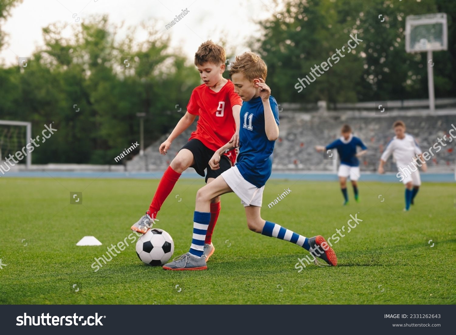 Boys playing football game on a school tournament. Football soccer match for children. Dynamic, action picture of kids competition during playing football #2331262643
