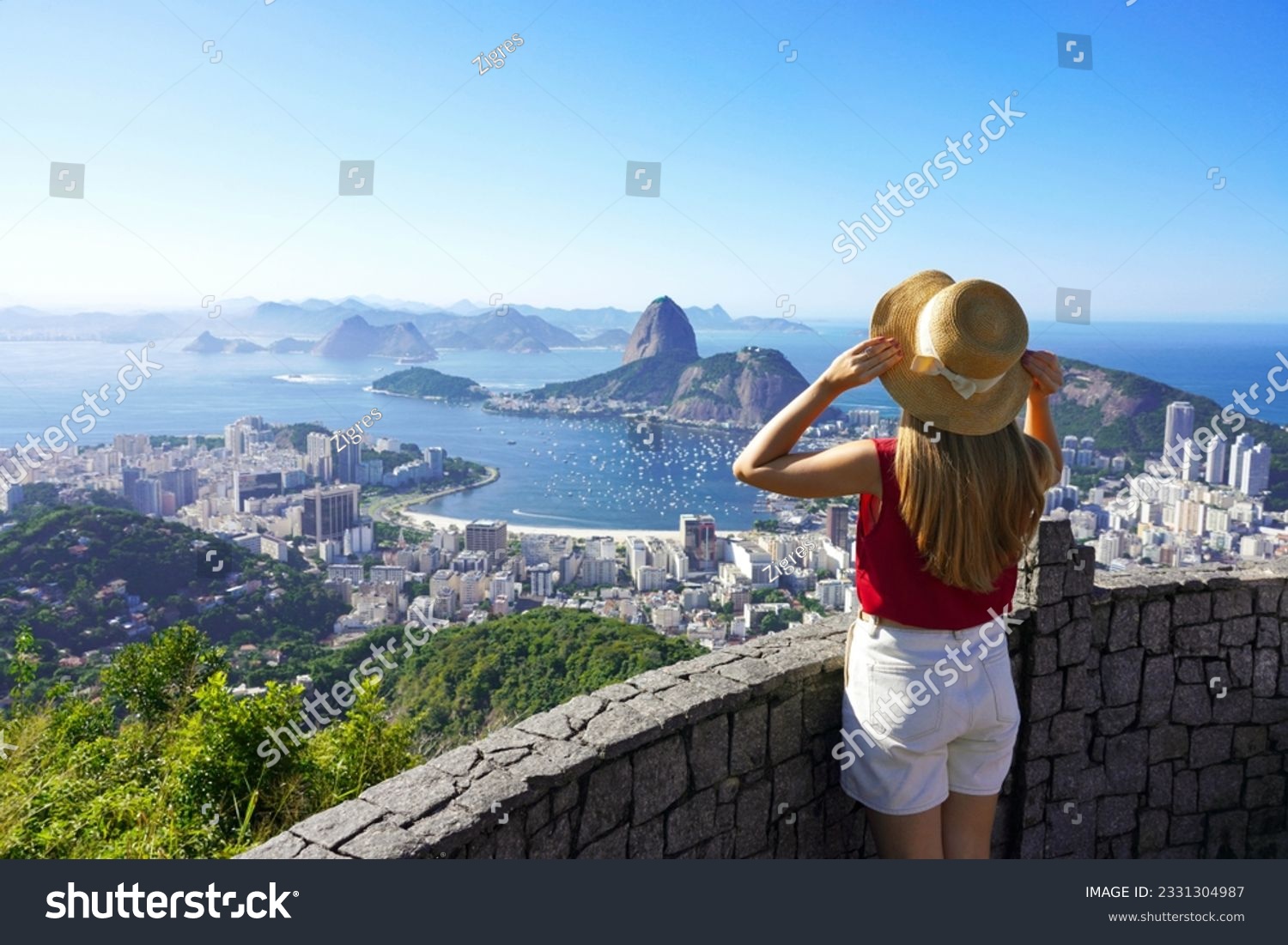 Holidays in Rio de Janeiro. Rear view of tourist woman enjoying sight of famous Guanabara Bay with Sugarloaf Mountain in Rio de Janeiro, UNESCO World Heritage, Brazil. #2331304987