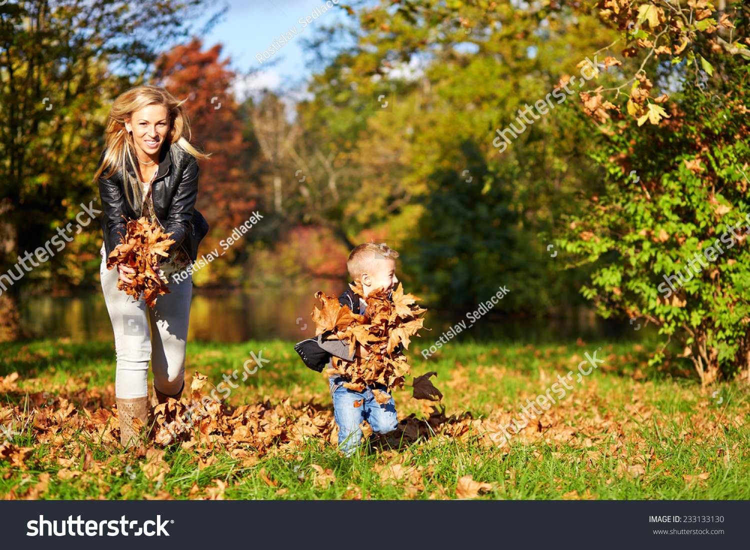 Little boy and mother playing together in the autumn park #233133130