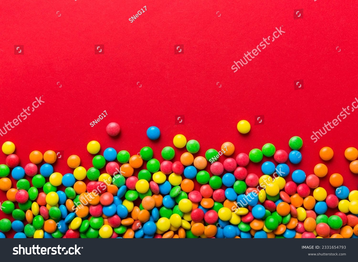 Mixed collection of colorful candy, on colored background. Flat lay, top view. frame of colorful chocolate coated candy. #2331654793