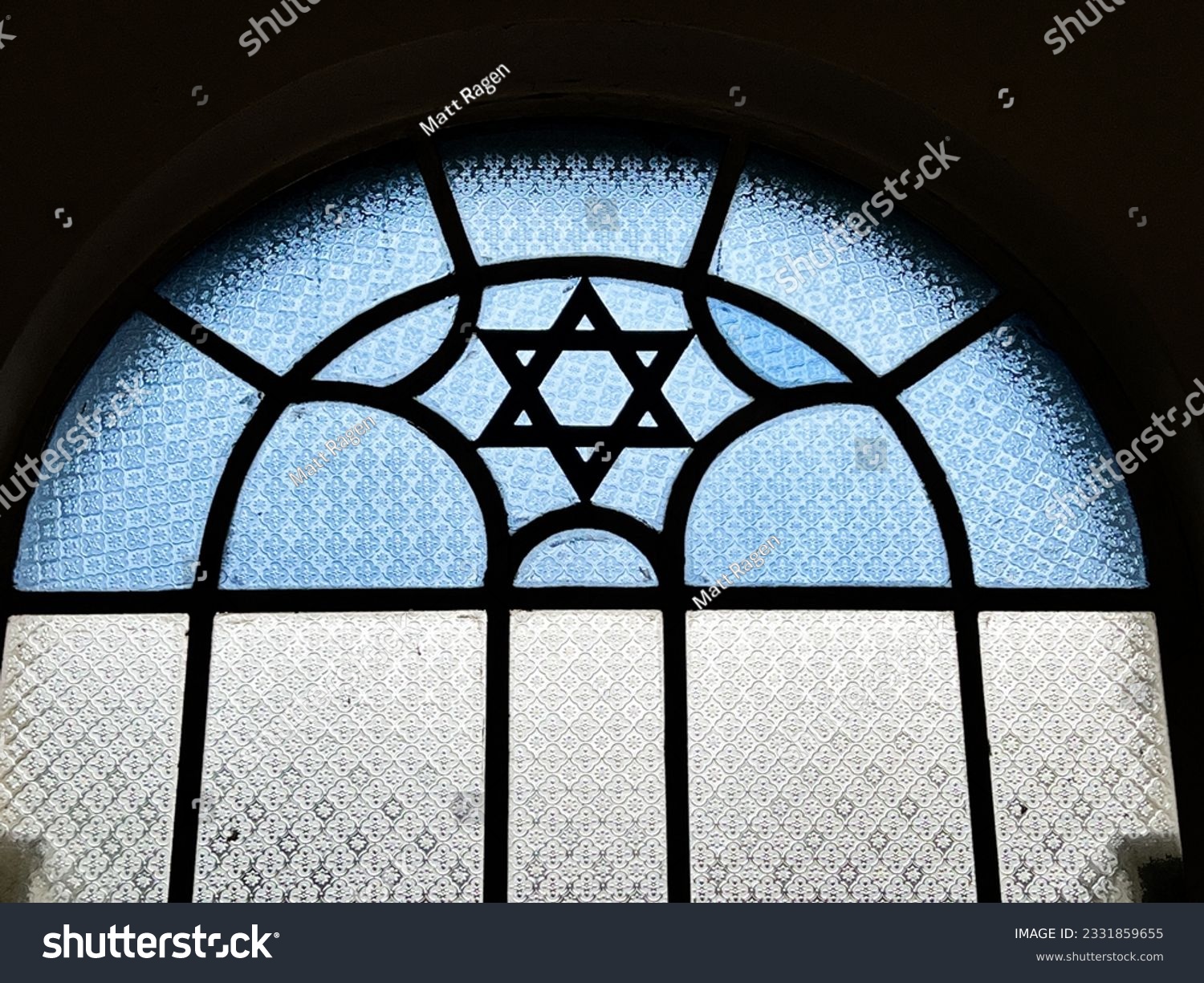 A stained glass window in a Singapore synagogue features a Star of David in blue and white glass as an architectural feature. #2331859655
