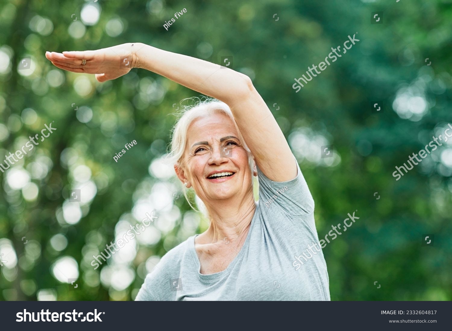 Portrait of a happy beautiful elderly senior mature woman exercising and stretching outdoors #2332604817