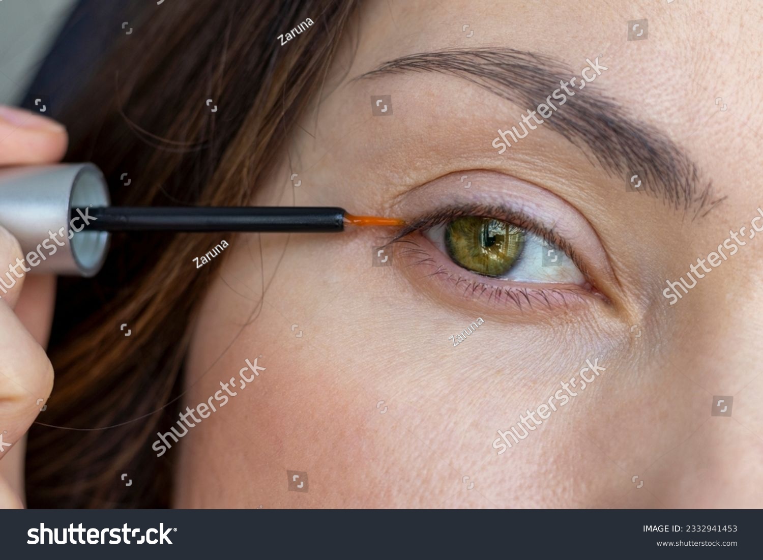 A woman applies eyelash growth product, close up #2332941453