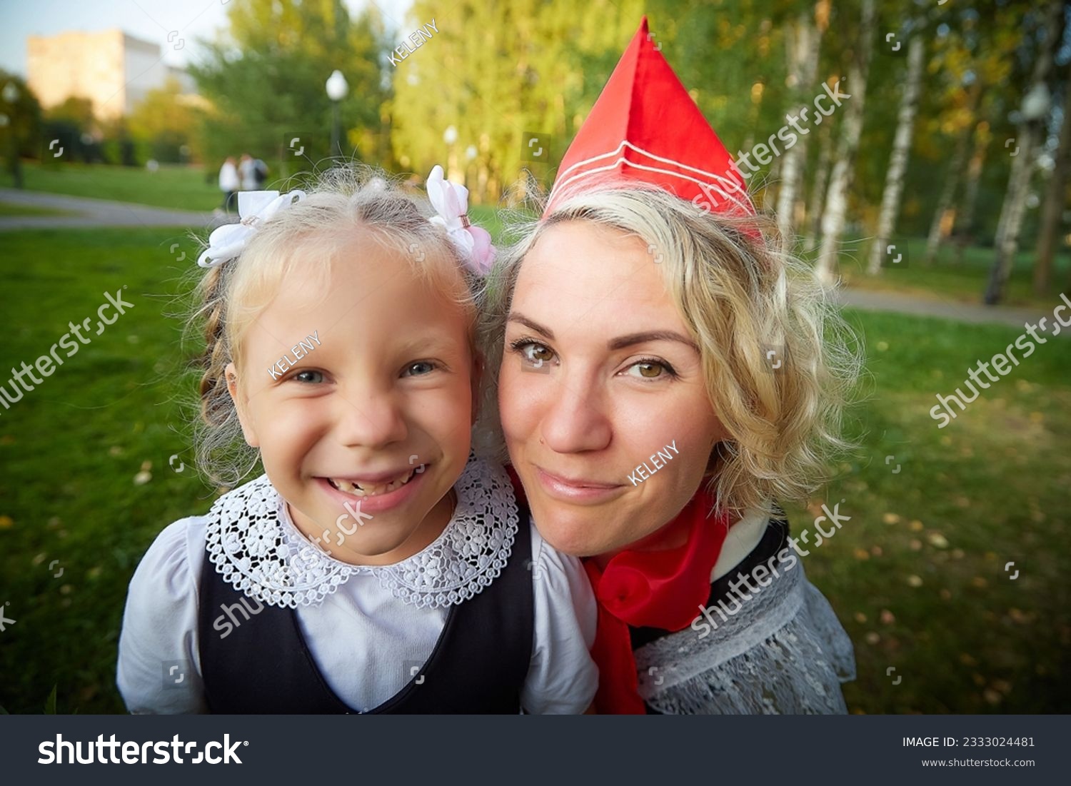 Young and adult schoolgirl on September 1. Generations of schoolchildren of USSR and modern Russia. Female pioneer in red tie and October girl in modern uniform. Mother and daughter having fun #2333024481