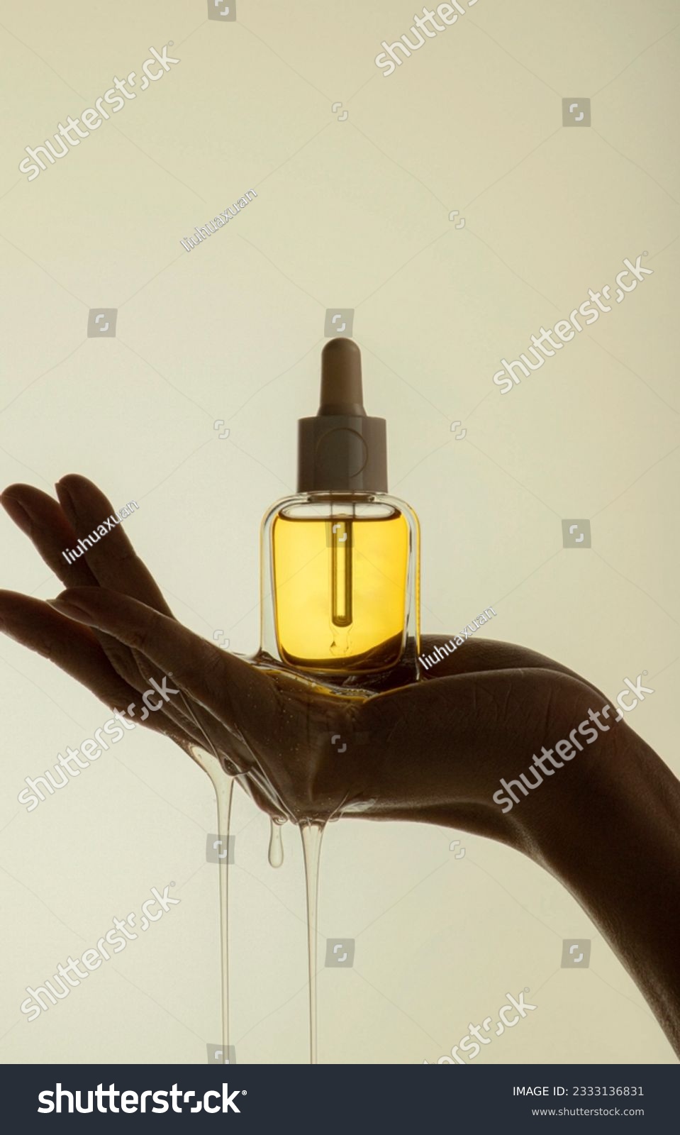 Holding yellow transparent skin care product essence backlight #2333136831