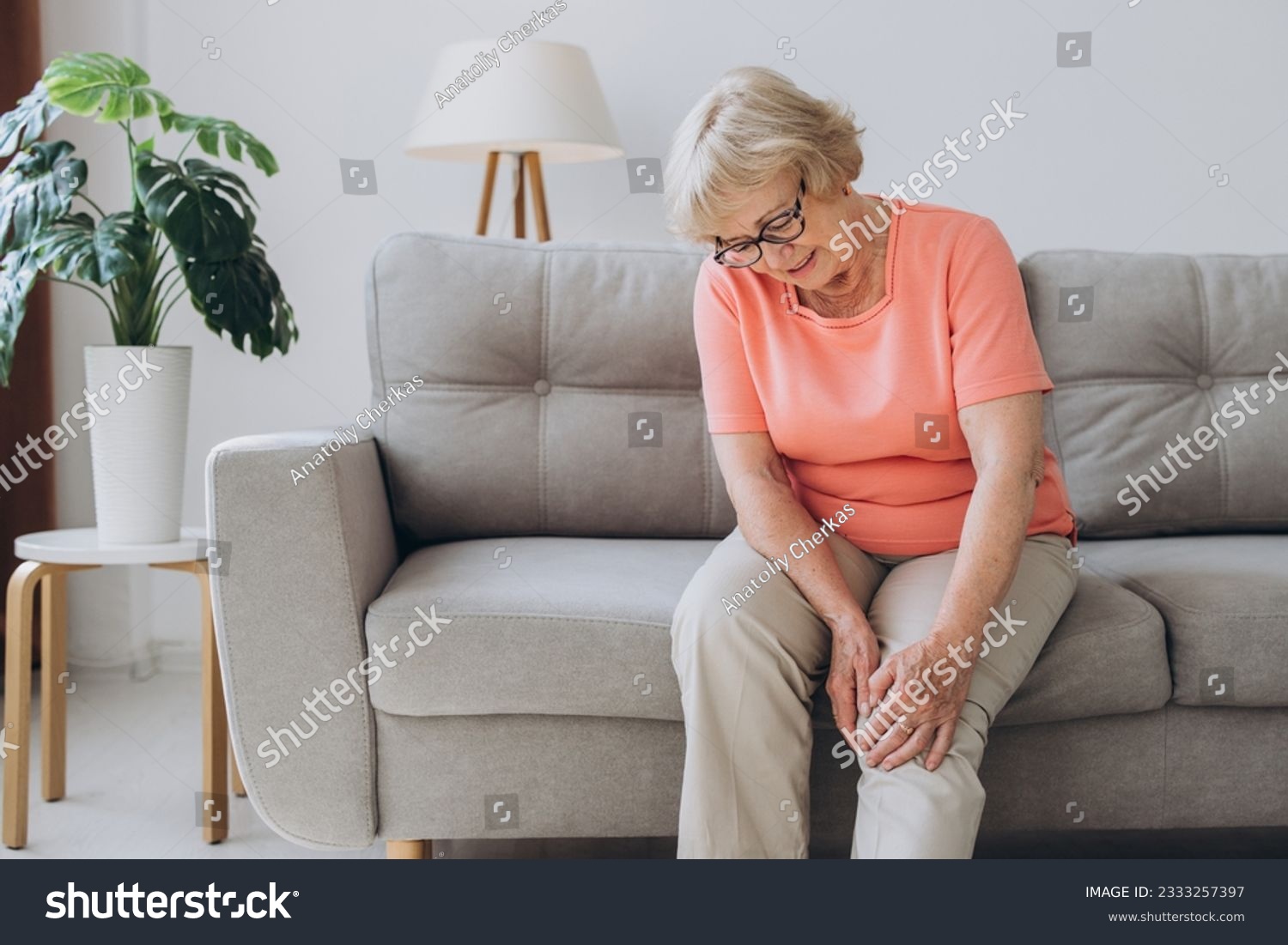 Senior woman suffering from pain in knee at home #2333257397