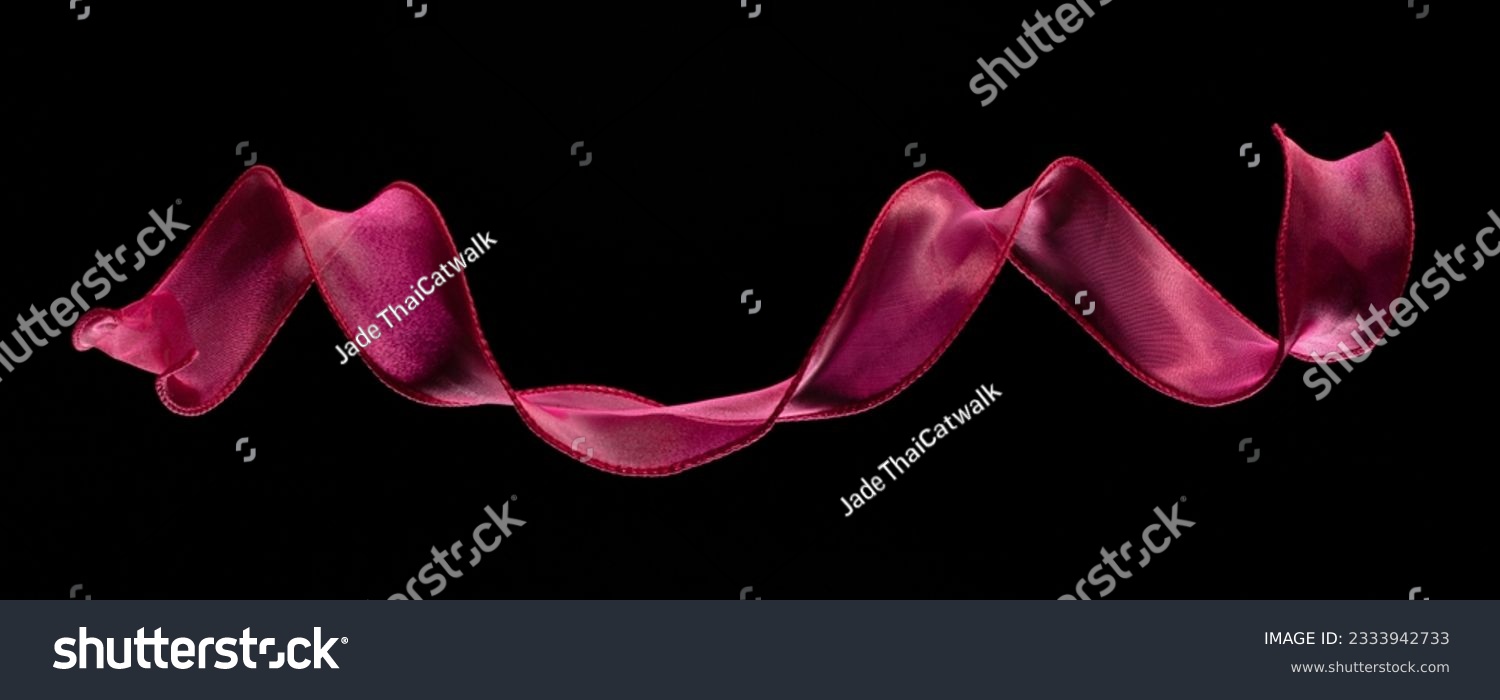 Red rose ribbon long straight fly in air with curve roll shiny. Red yellow ribbon for present gift birthday party to wrap around decorate, curl curve long straight. Black background isolated #2333942733