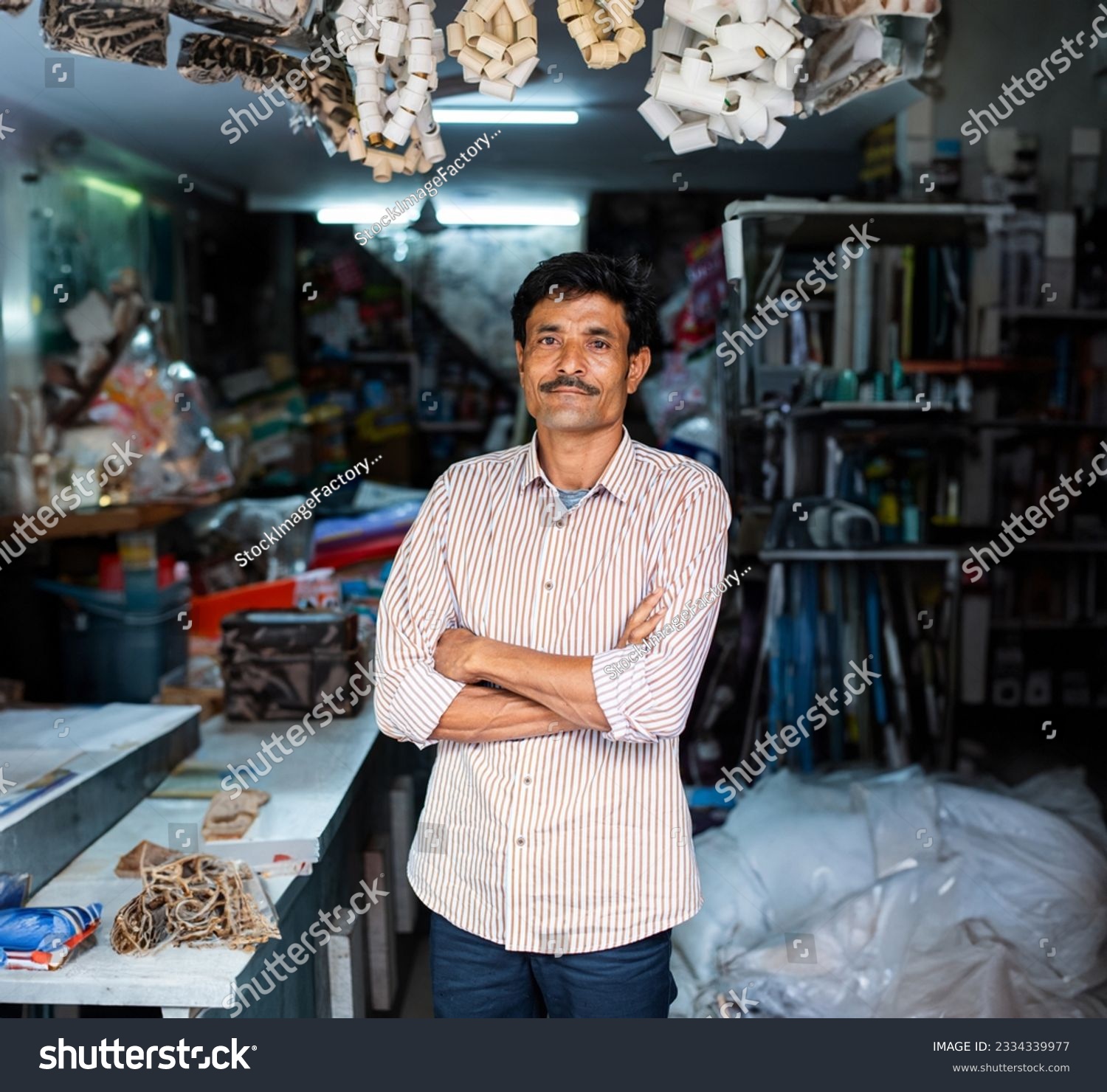 Indian hardware shop owner, salesman, vendor or seller showing products, customer service concept #2334339977