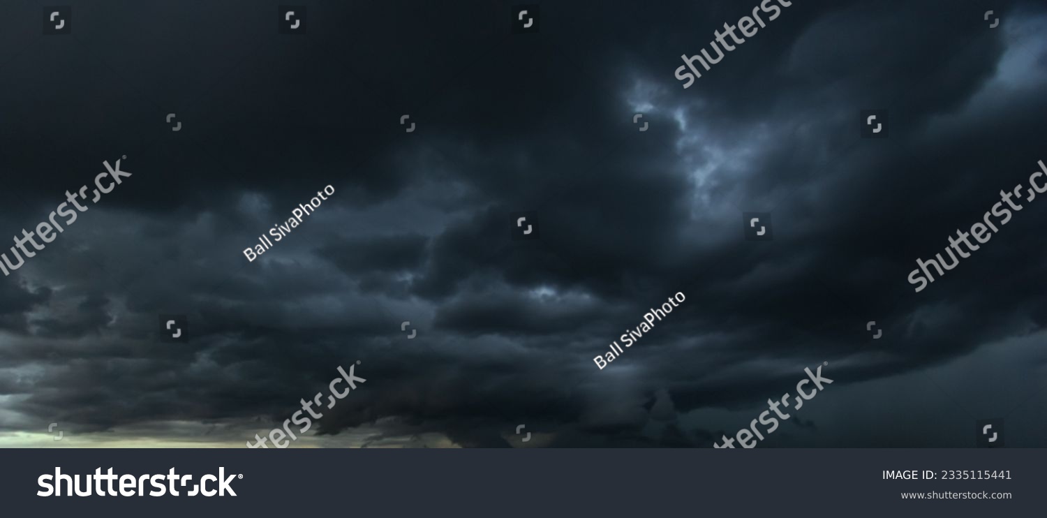 The dark sky with heavy clouds converging and a violent storm before the rain.Bad or moody weather sky and environment. carbon dioxide emissions, greenhouse effect, global warming, climate change #2335115441