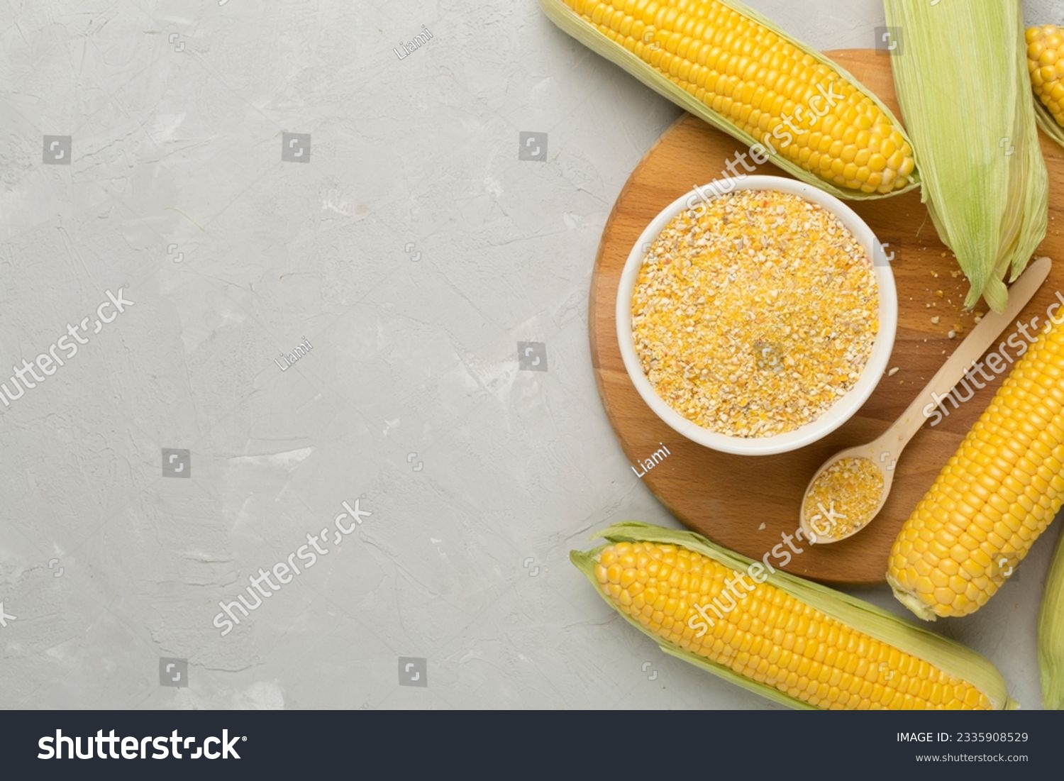Corn groats with fresh cobs on concrete background, top view #2335908529