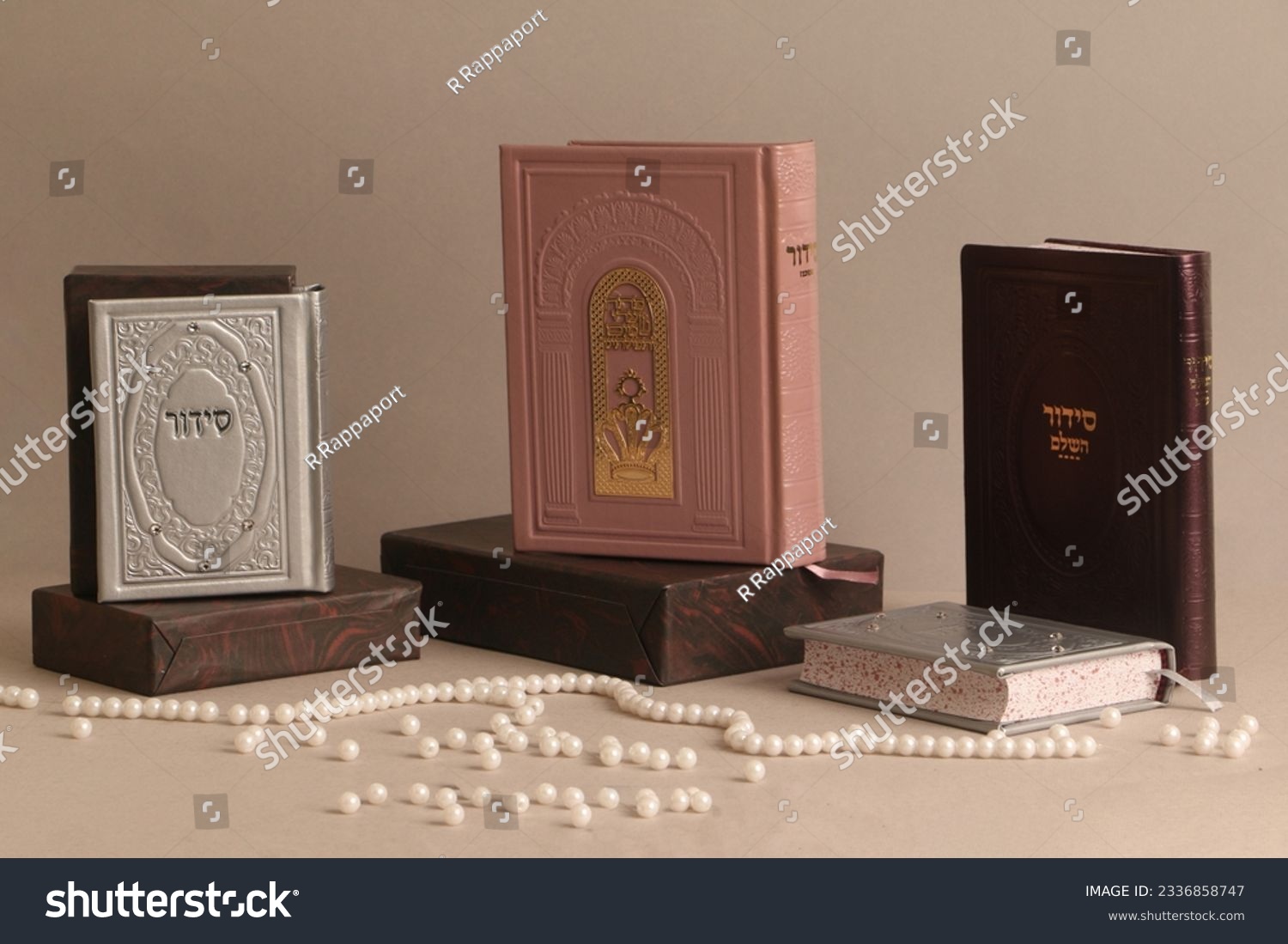 jewish Prayer books. On the pink book it is written: "Open the gates of heaven to our prayers", on the other books is written "Siddur" #2336858747