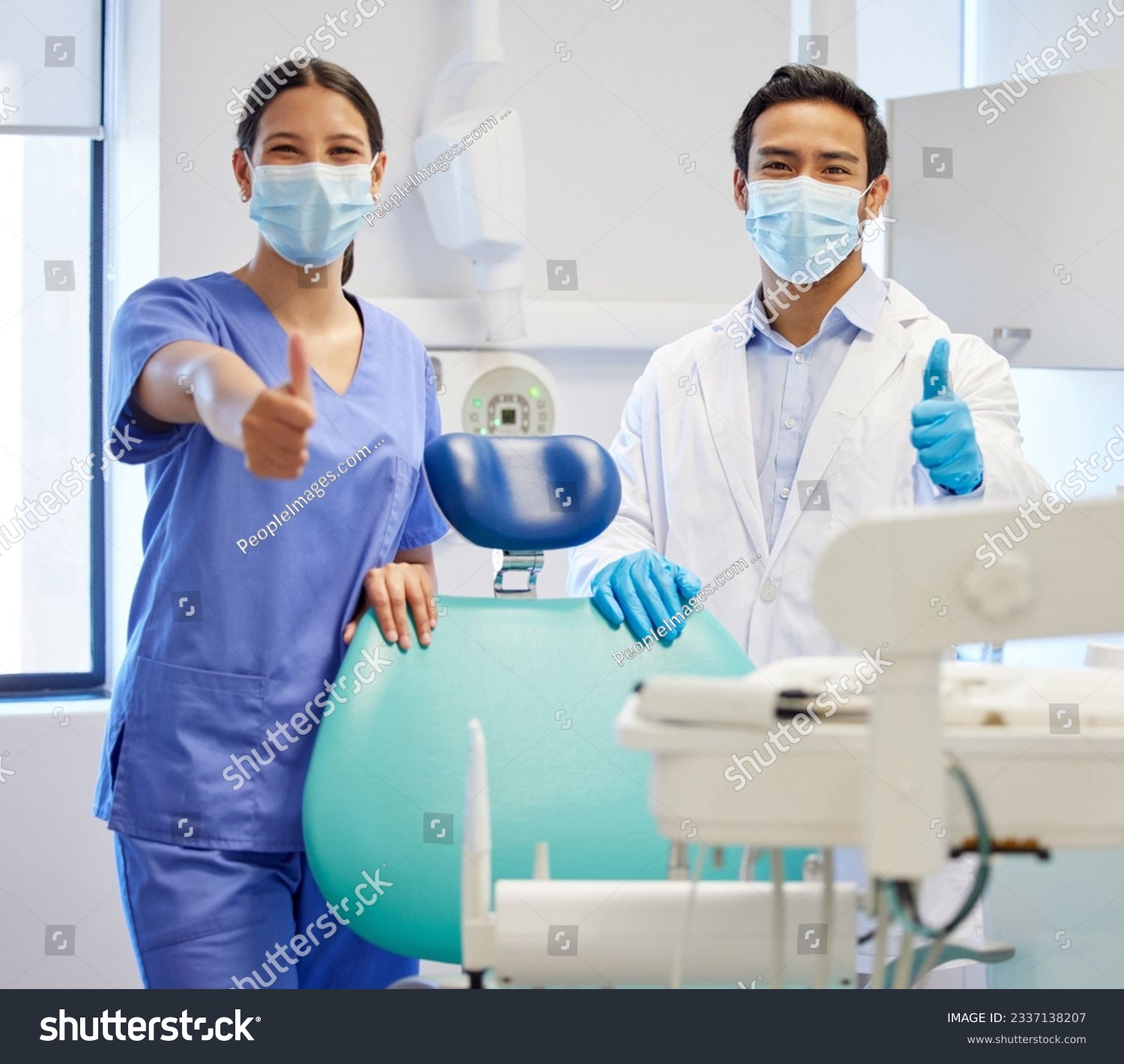 Dentist team, face mask and thumbs up portrait for.medical industry and teamwork. Assistant woman and asian man or healthcare staff together for dental care, oral health and wellness at practice #2337138207