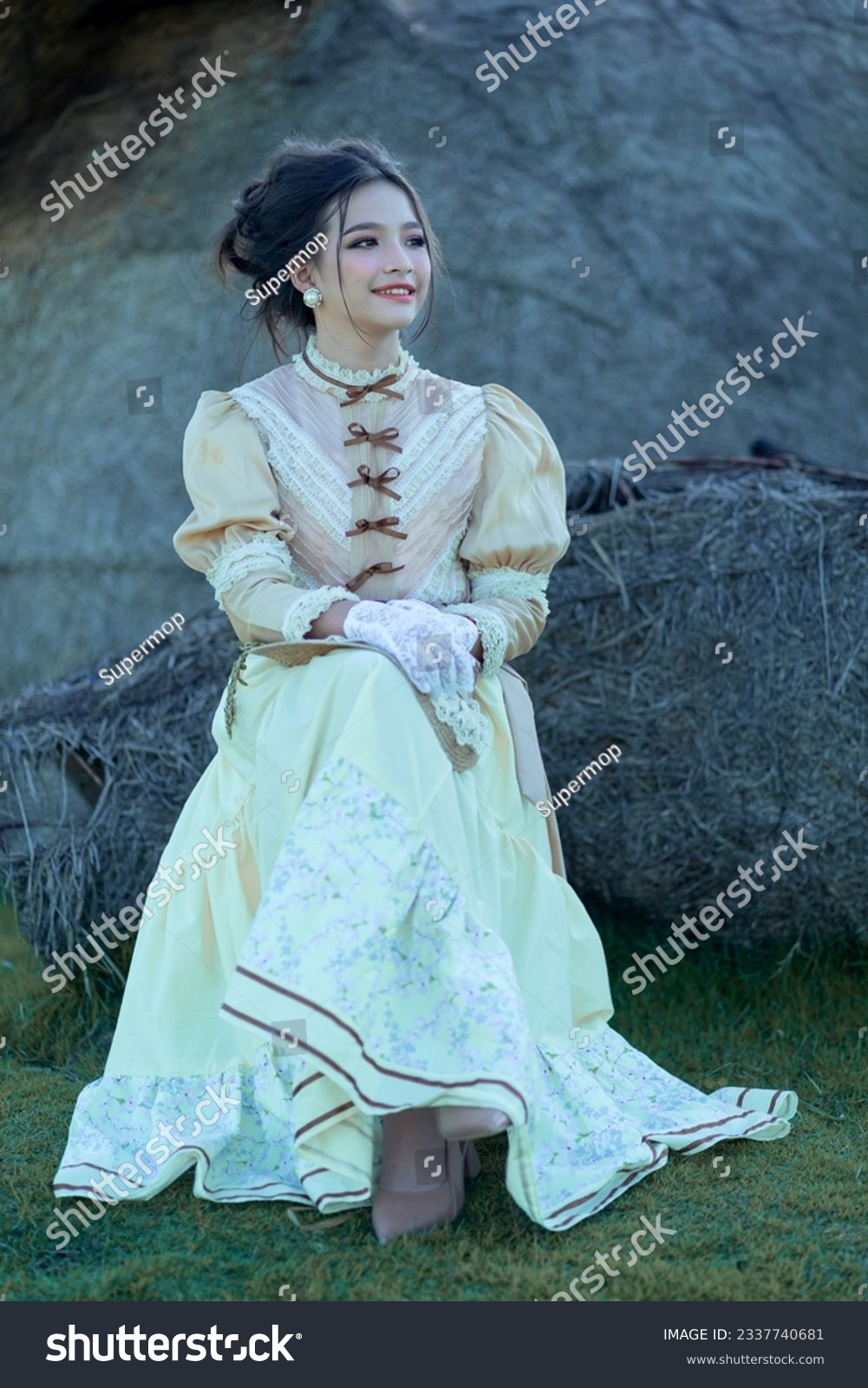 A pretty young Asian teenage girl wearing Victorian or Edwardian-era dresses is happy and relaxing on a good day. Portrait young girl in retro vintage old fashion style concept. #2337740681