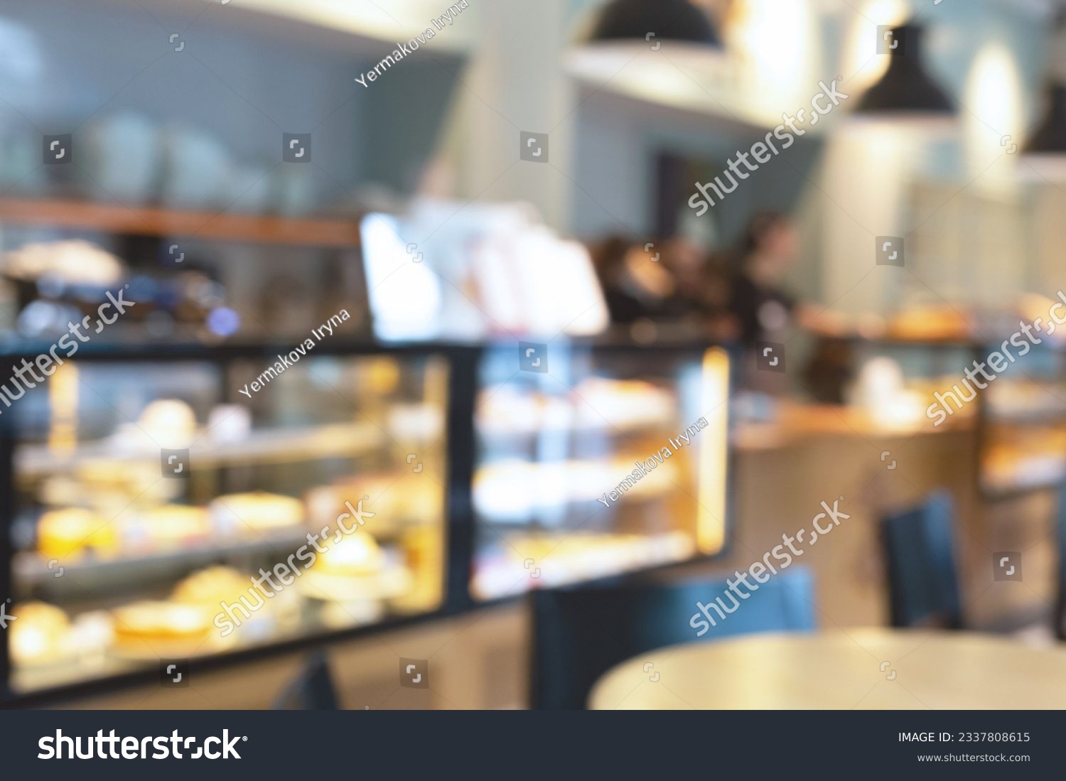 Blurred image of pastry shop interior background. Defocused view of a showcase with confectionery. Bokeh lighting. #2337808615