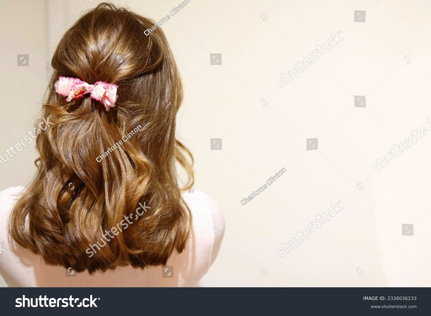 Young blonde woman with hair styled half-back, secured with a bow clip. Valentines day hairstyle. Sweet hairstyle. Healthy, glossy hair. Cool vintage filter.  #2338036233