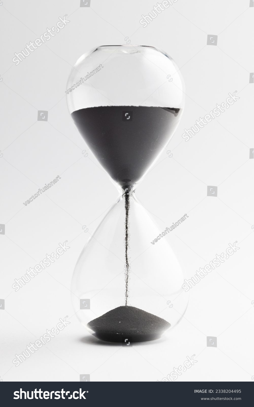Close up of hourglass with black sand and copy space on white background. Time, timekeeping, shape and colour concept. #2338204495