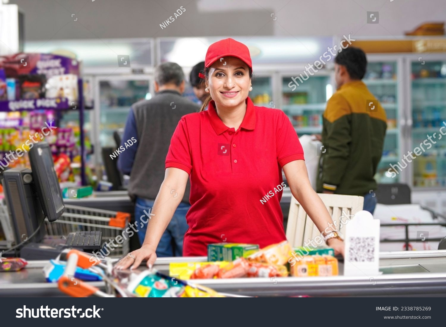 Young and confident female seller standing at supermarket. #2338785269