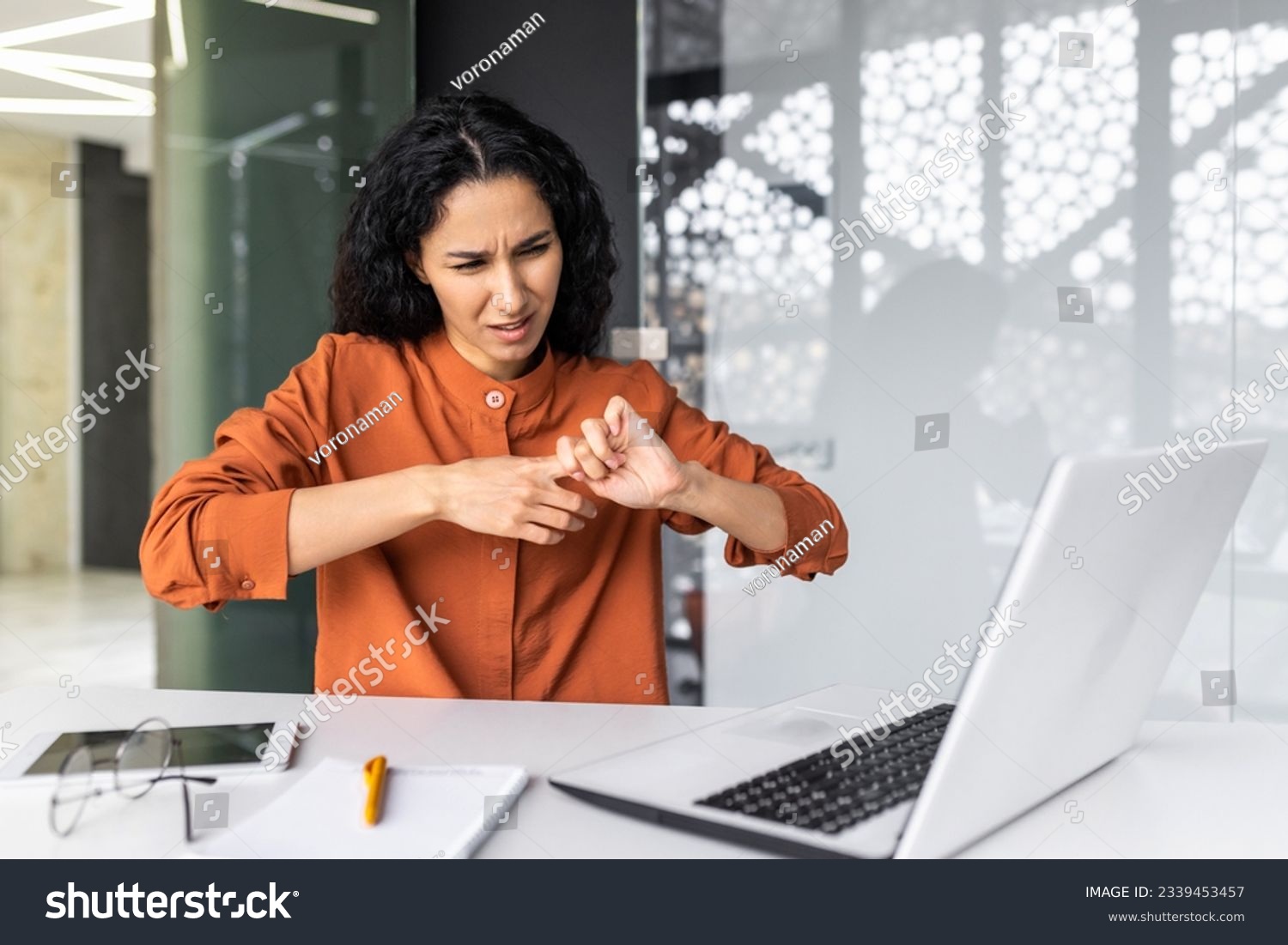 Female office worker overtired has severe pain in fingers and joints, Hispanic woman overworked at workplace with laptop at work. #2339453457