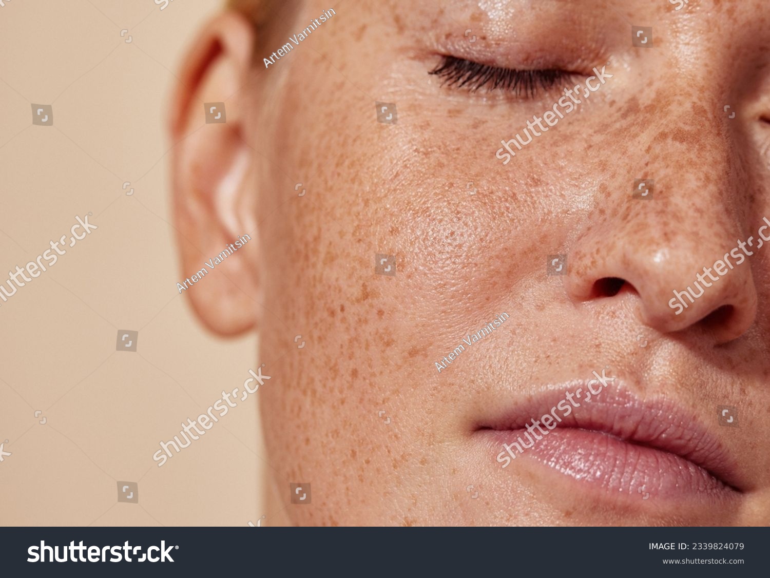 Cropped shot of the face of a young woman with freckles #2339824079