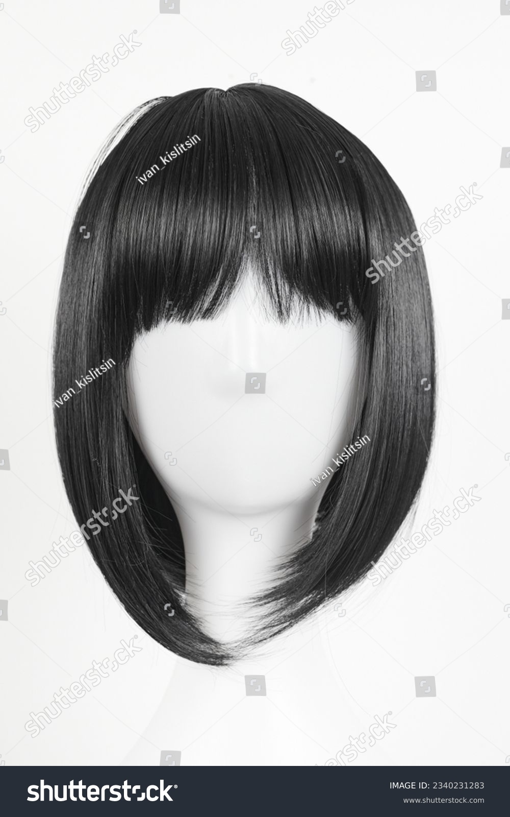 Natural looking black wig on white mannequin head. Medium length straight hair with bangs on the metal wig holder isolated on white background, front view #2340231283