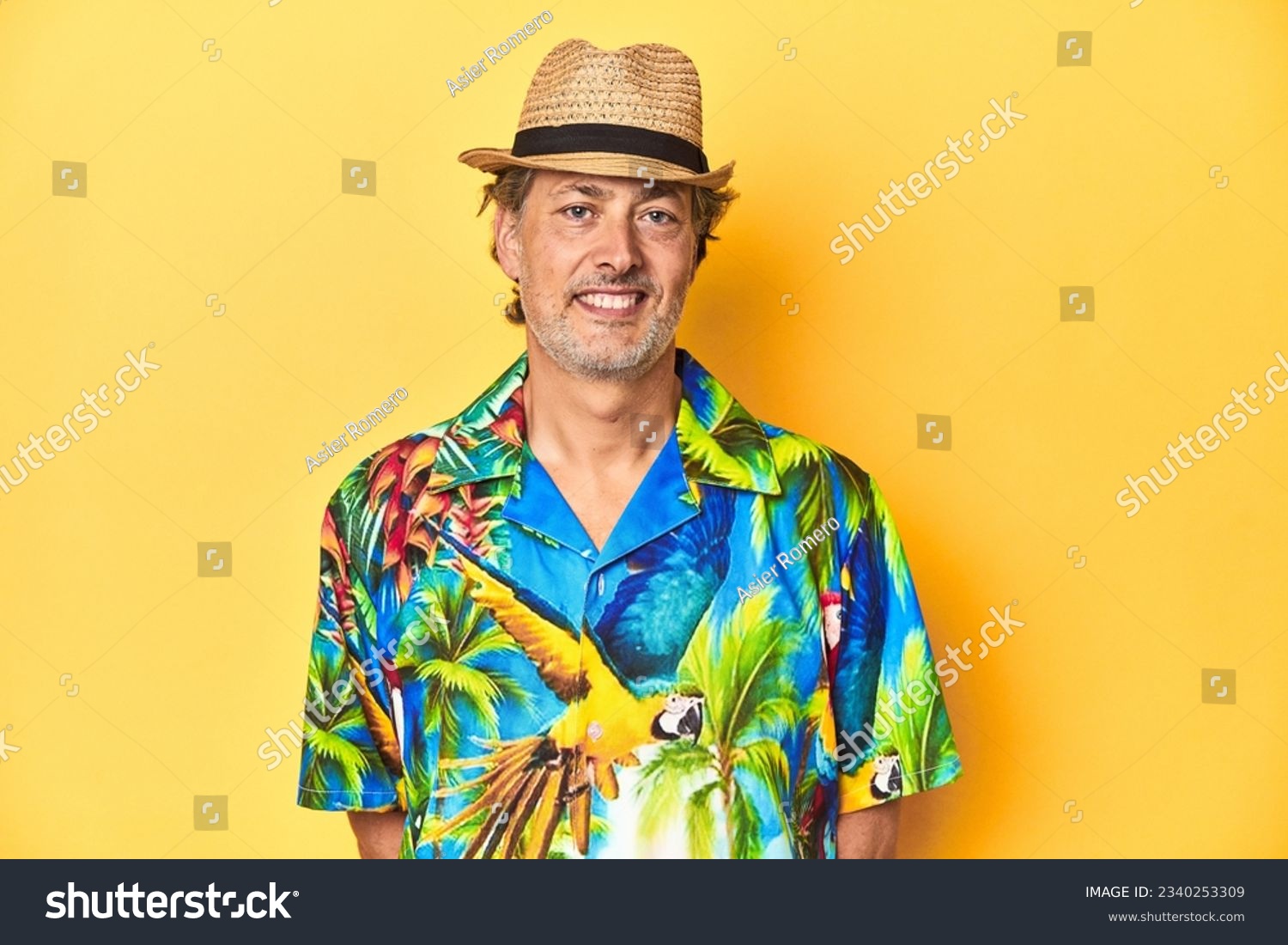 Cheerful middle-aged man in Hawaiian shirt emanating summer vibes on a yellow background #2340253309