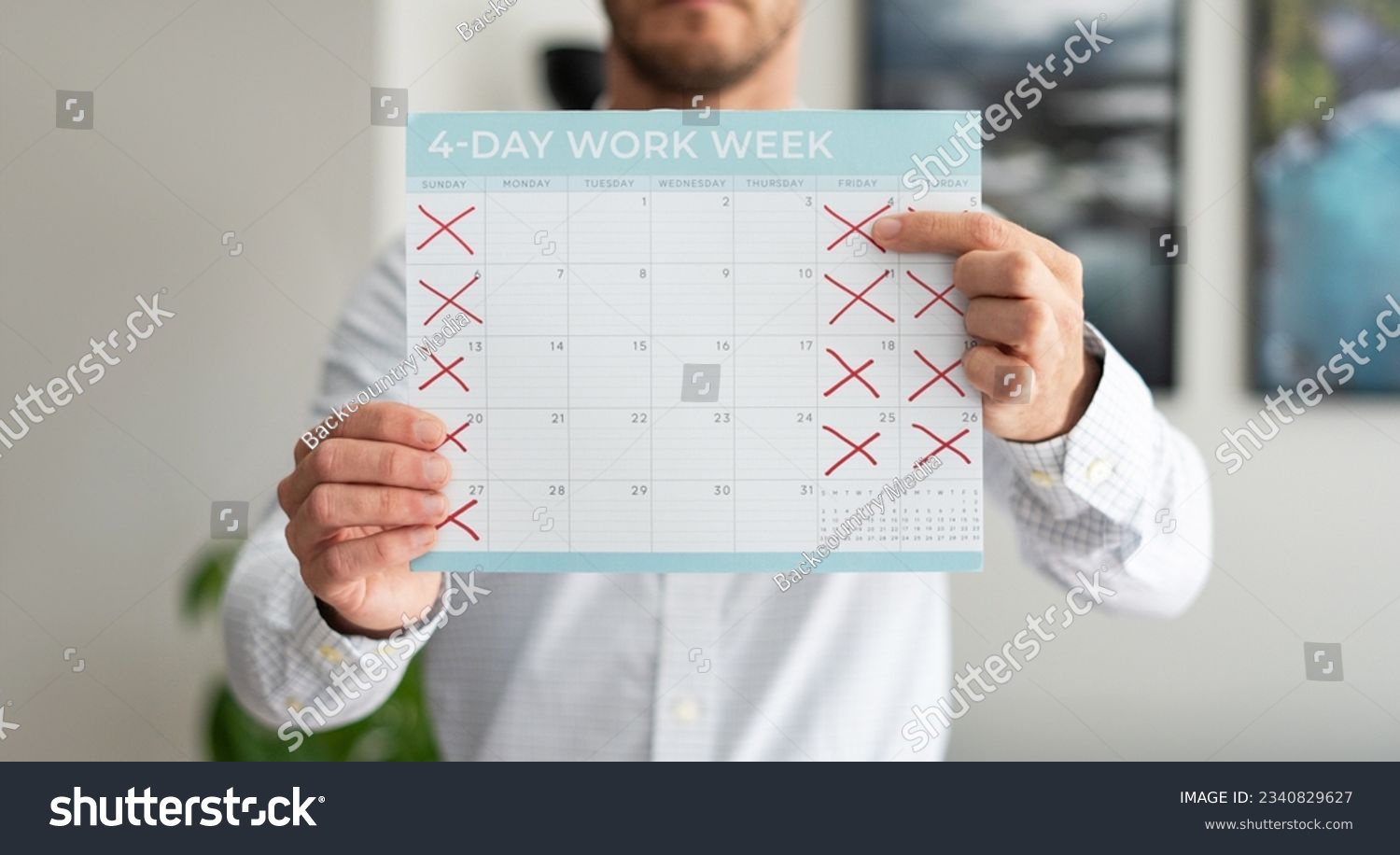 Man holding a calendar pointing to a 4-day work week concept #2340829627
