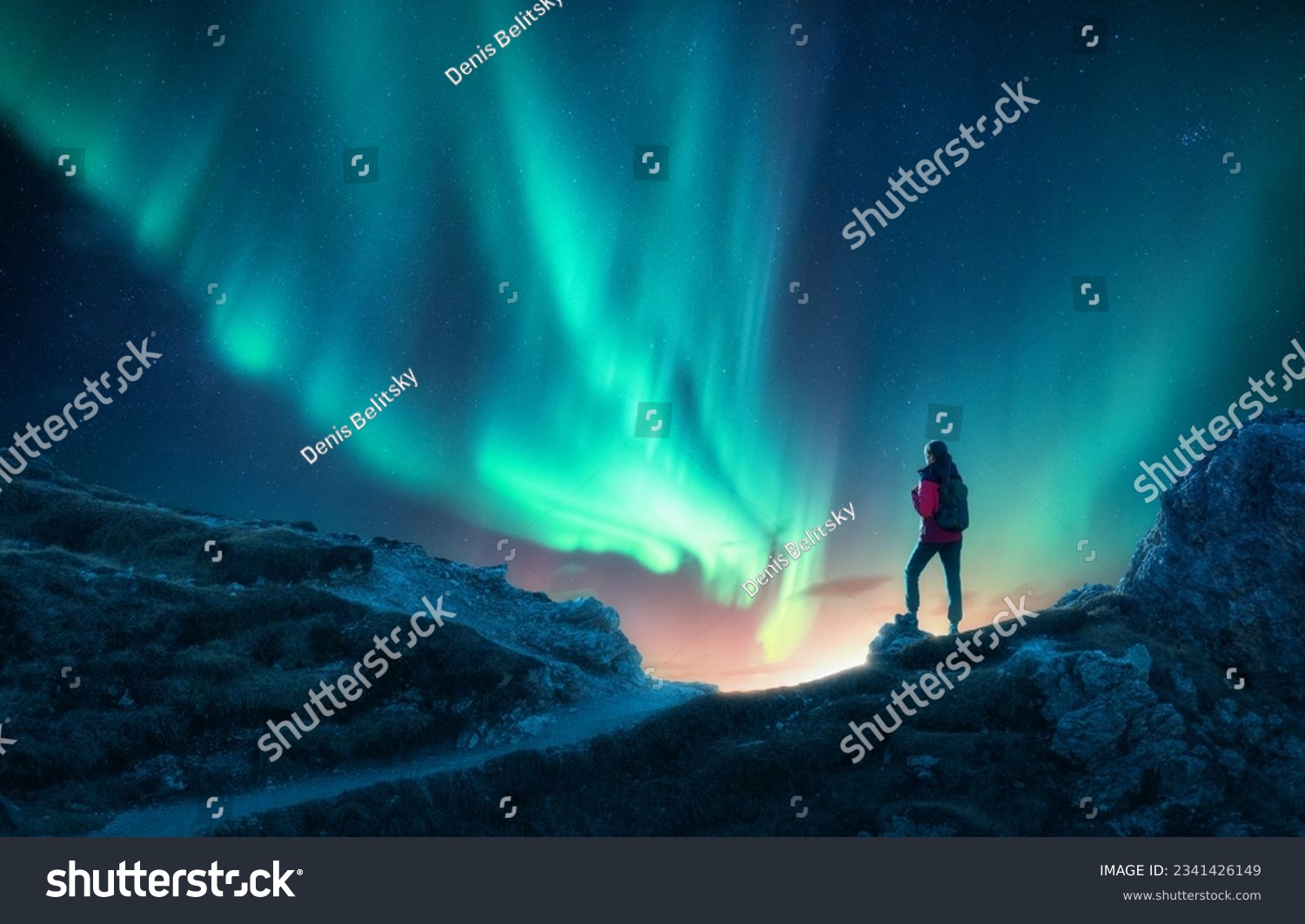 Northern lights and woman on mountain peak at night. Aurora borealis and silhouette of alone girl on mountain trail. Landscape with polar lights. Sky with stars and bright aurora. Travel background #2341426149