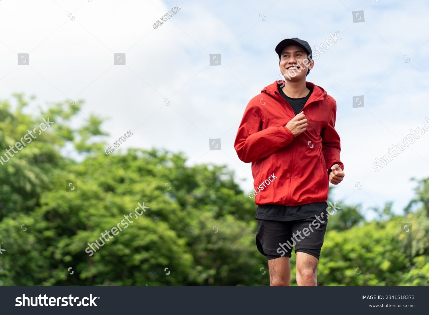 Attractive Young indian man wearing sportswear running on track at sport stadium. Asian Fit man jogging outdoor cross the finish line. Exercise in the morning. Healthy and active lifestyle concept. #2341518373