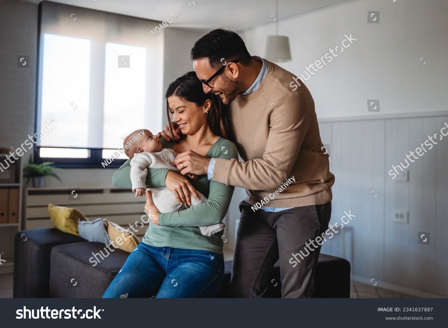 Peaceful young married couple enjoying being family, parents, holding new born baby in arms #2341637887