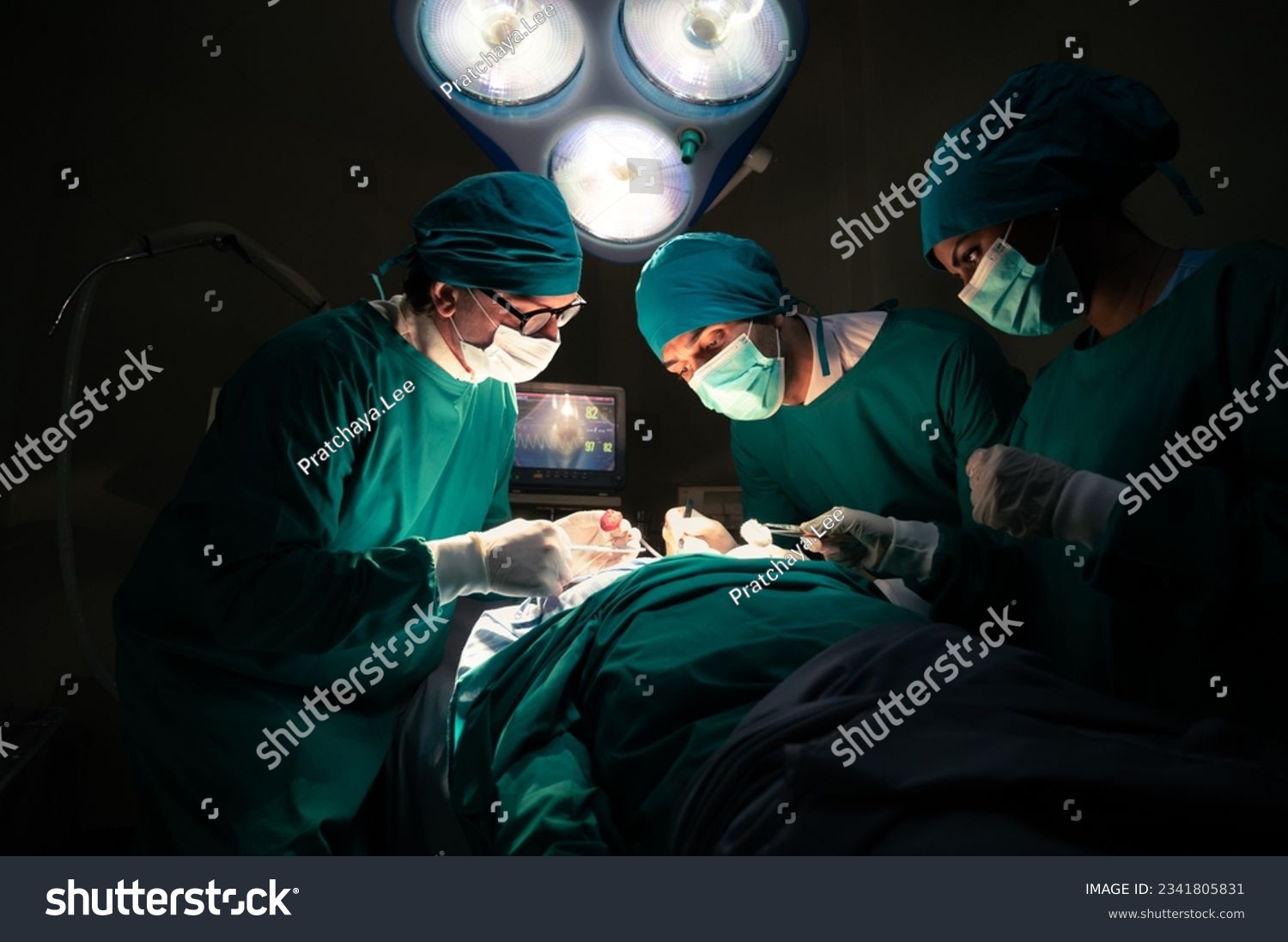 Group of concentrated surgical doctor team doing surgery patients in hospital operating theater. Professional medical team doing critical operations #2341805831