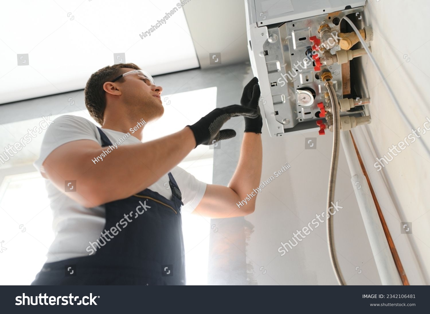 Gas engineer checking and cleaning a boiler during the inspection at home. #2342106481