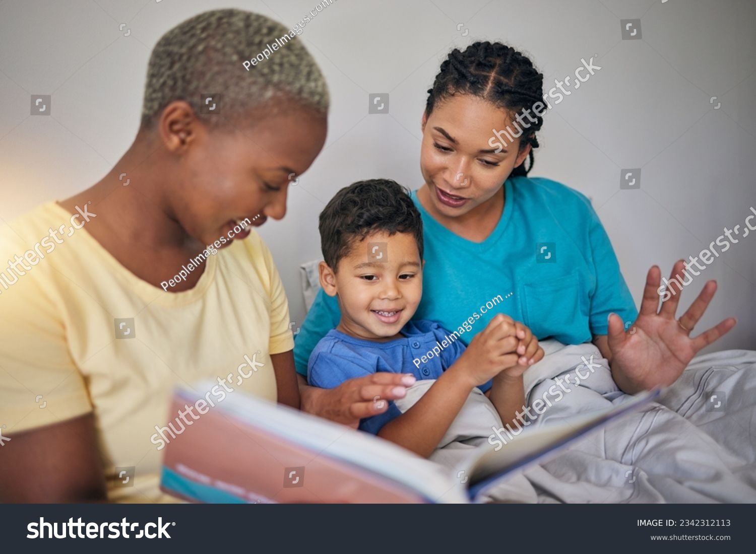 Reading, LGBT family and child with a book in bed for knowledge, education and learning. Adoption, lesbian or gay women or parents and foster kid together in home bedroom with story for quality time #2342312113