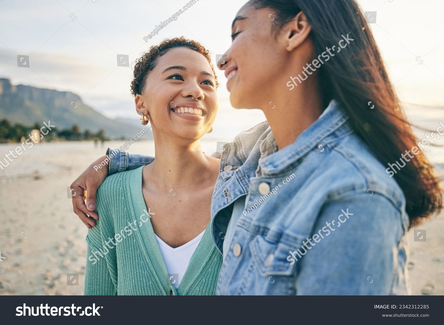 Beach, hug and queer couple with love, lgbtq and happiness with marriage, sunset or adventure. Lesbian, female people or women on a seaside holiday, vacation or quality time with a journey or embrace #2342312285