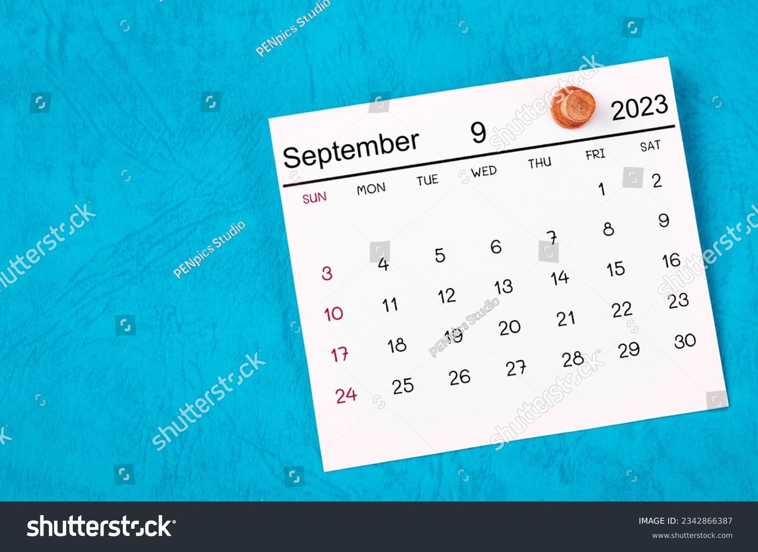 September 2023 and wooden push pin on blue background. #2342866387