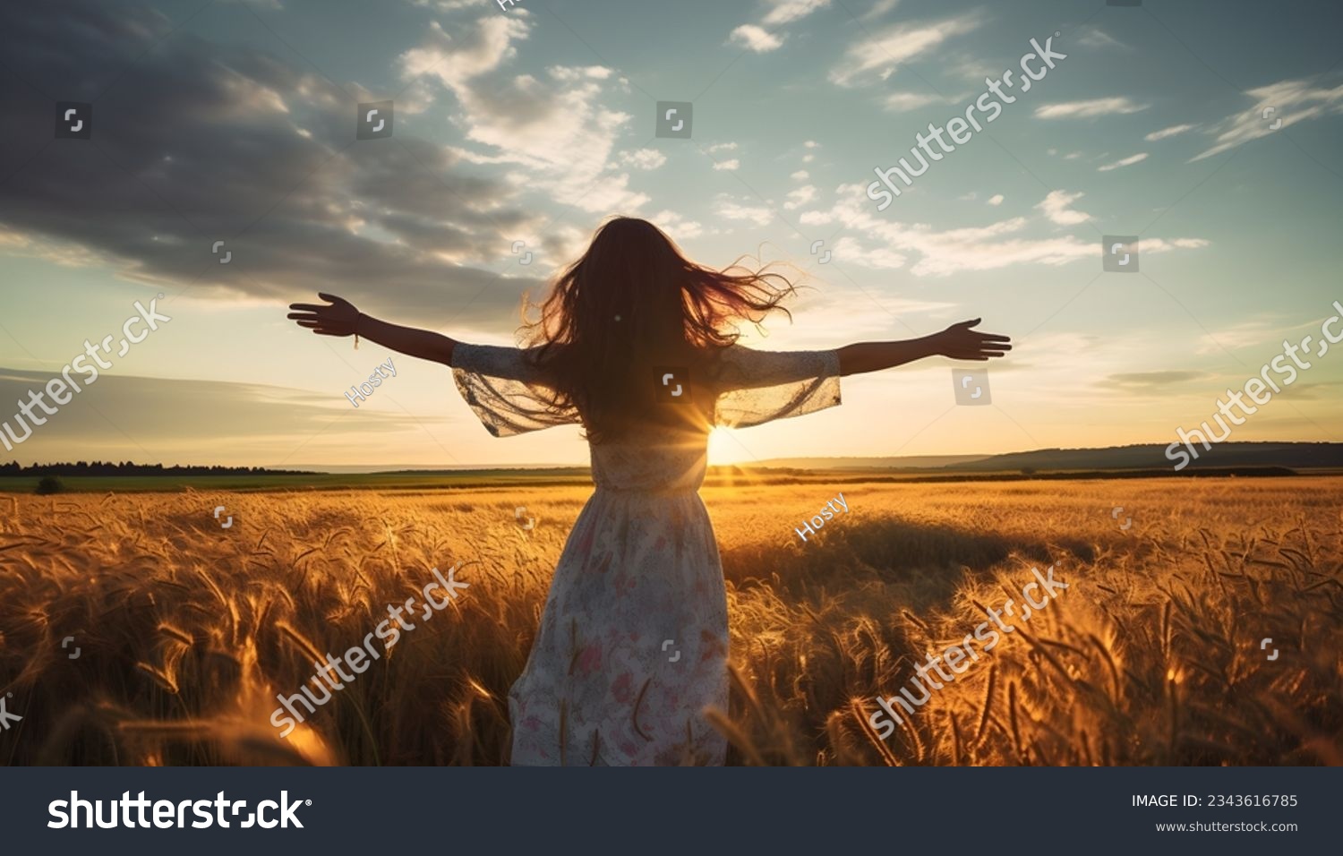 Girl at sunset with outstretched arms on a field with grain #2343616785