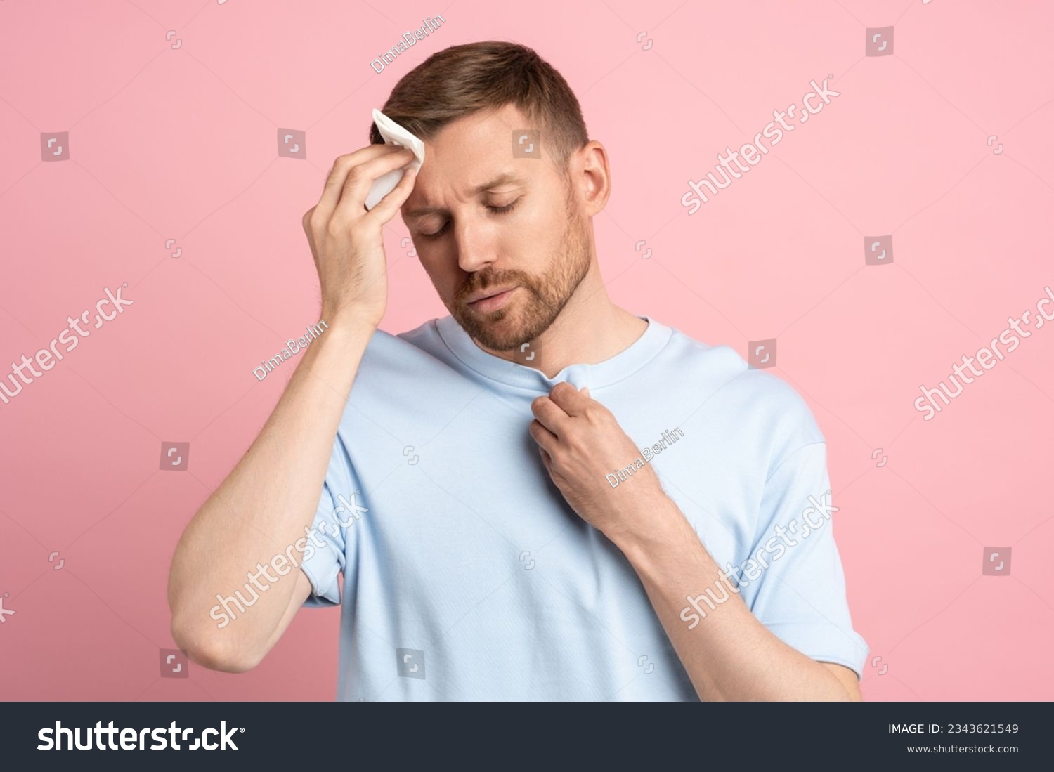 Man suffering from heat stuffiness wiping sweat on forehead with paper napkin isolated on pink background. Exhausted overheated bearded male with closed eyes. Summer hot weather, stuffy room concept. #2343621549