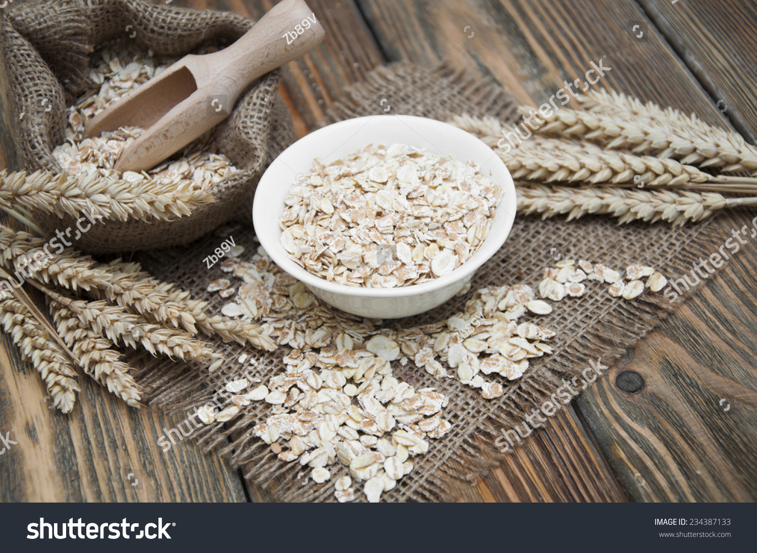 Bowl of oatmeal and wheat on dark wooden background #234387133