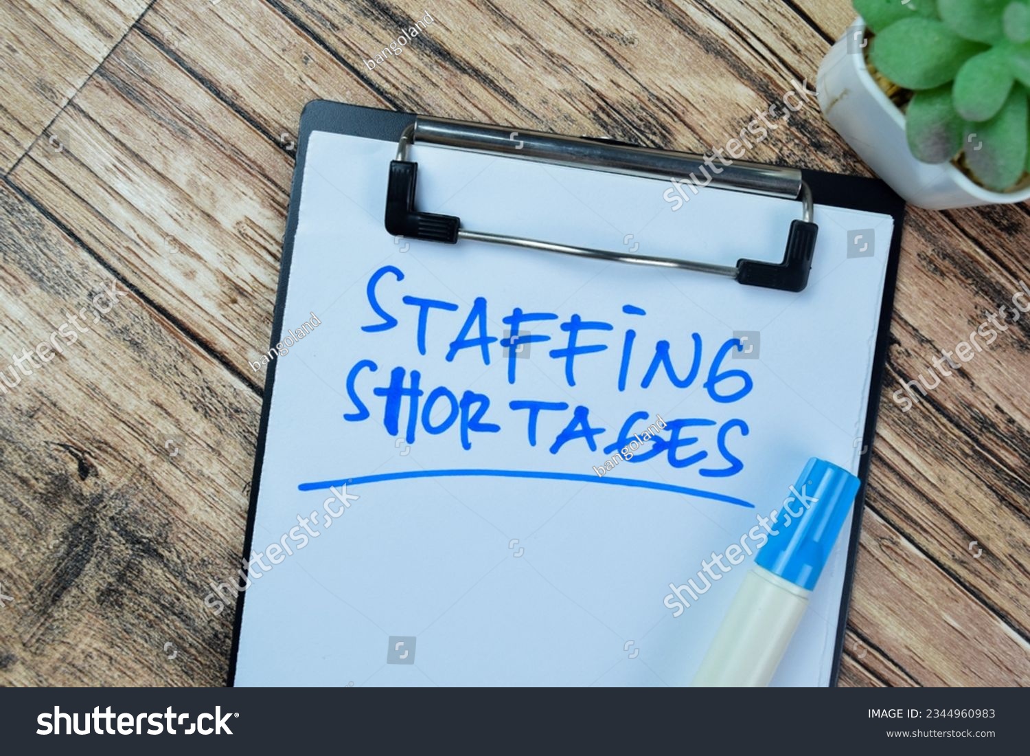 Concept of Staffing Shortages write on paperwork isolated on Wooden Table. #2344960983