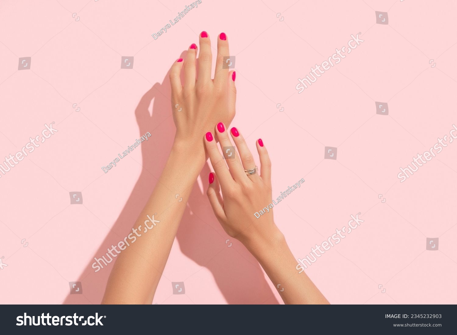 Womans hands with pink nail design. Manicure, pedicure beauty salon concept. Deep long shadows. #2345232903