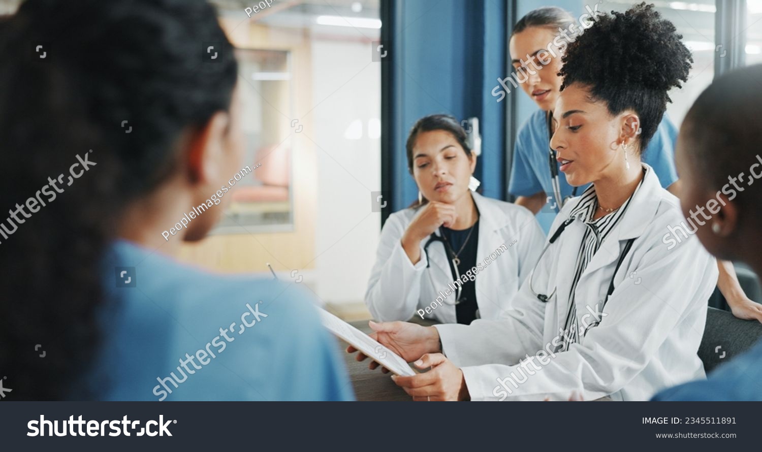 Doctors, nurse and women on clipboard in meeting, collaboration or teamwork for hospital planning, medical or life insurance. Talking, leadership and healthcare workers on paper in diversity research #2345511891