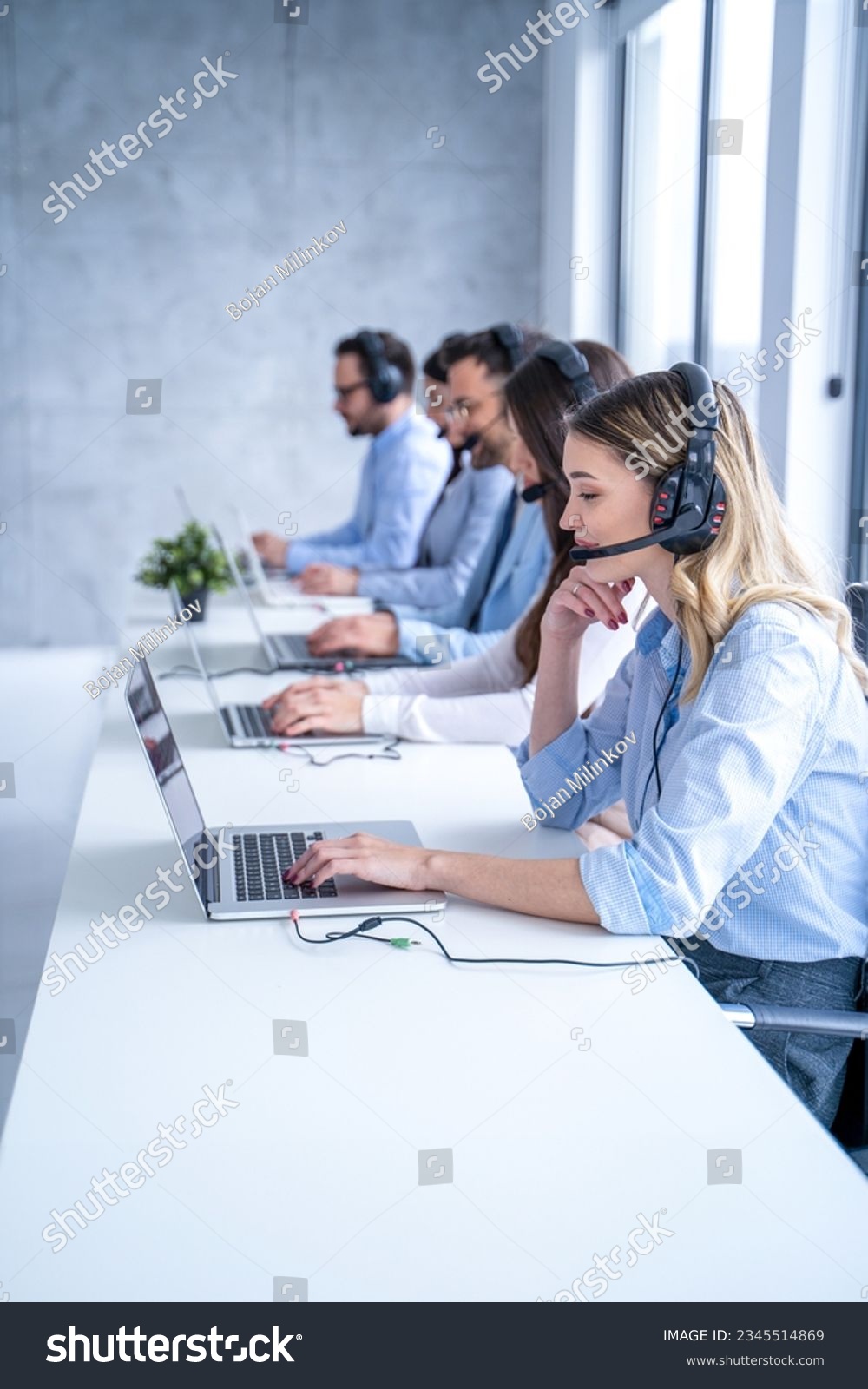 Smiling blond haired customer support agent woman listening attentively to the client's inquiries, demonstrating her dedication to providing top-notch service. #2345514869