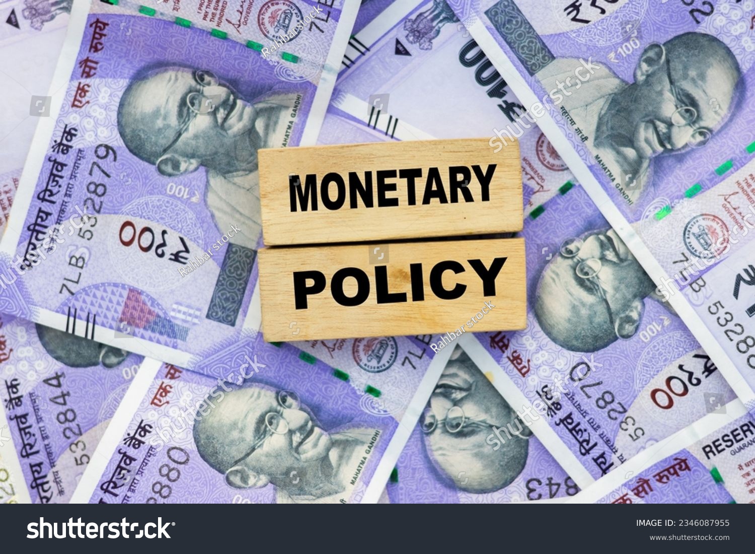 RBI monetary policy word on wooden block place on indian currency #2346087955