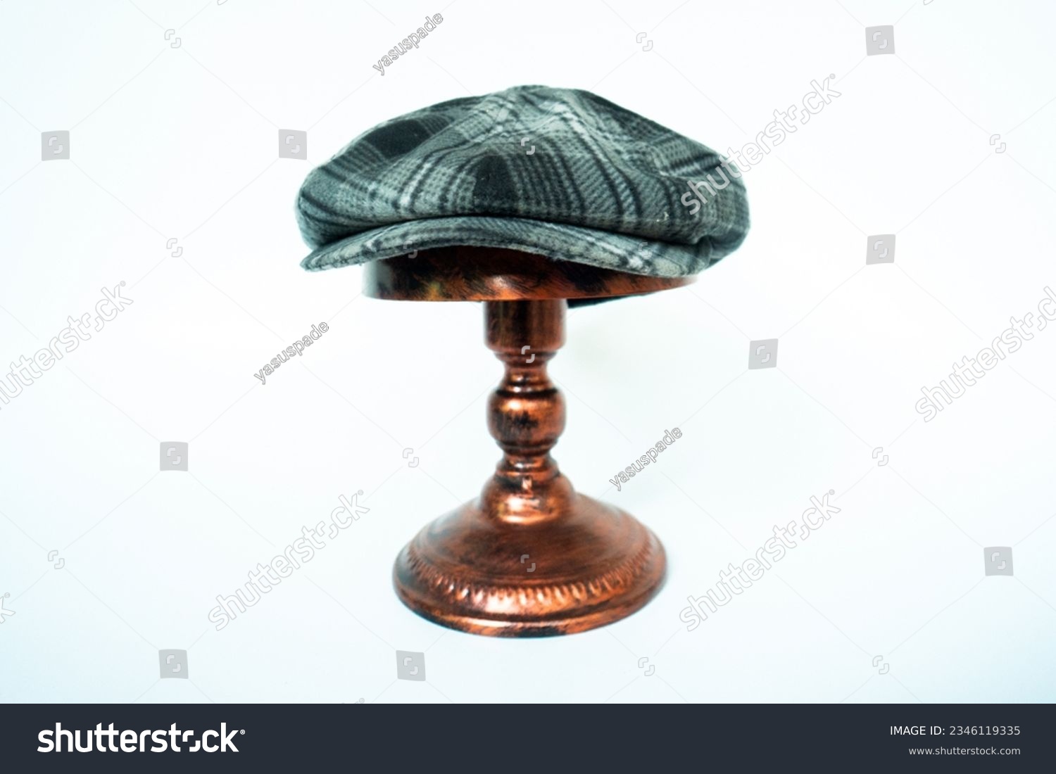 Studio photo concept for classic eight-panel newsboy cap with wool material. newsboy hat in black and white with a tartan pattern mounted on a bronze mannequin head on a white background. #2346119335