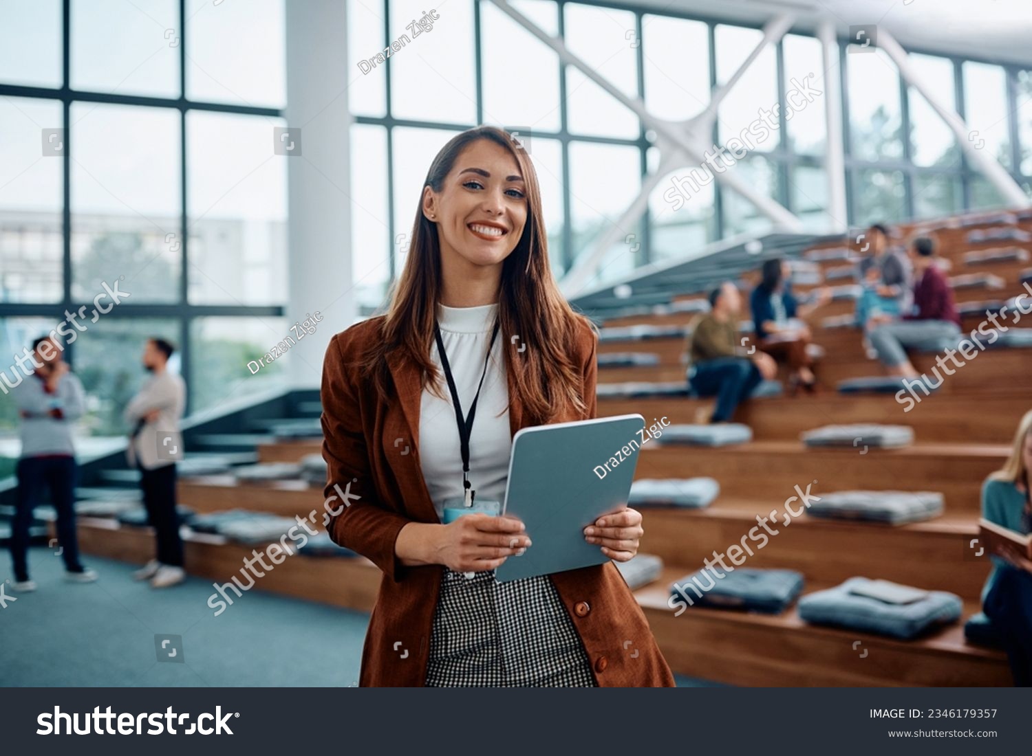 Happy female entrepreneur attending a business seminar in conference hall and looking at camera. #2346179357