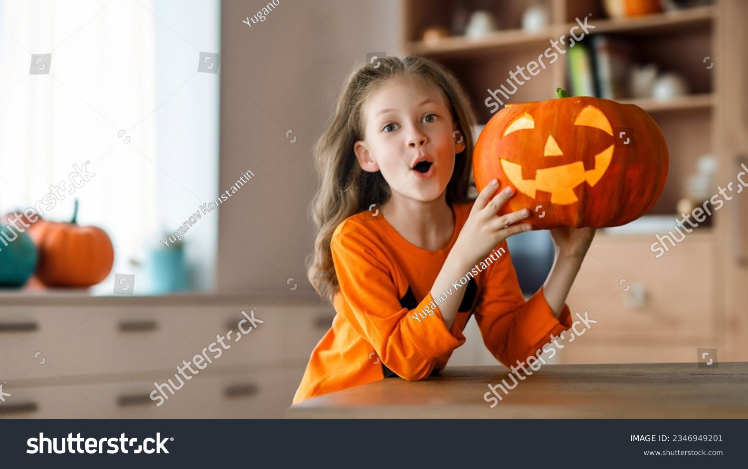 Cute little child girl with carving pumpkin. Happy family preparing for Halloween.  #2346949201
