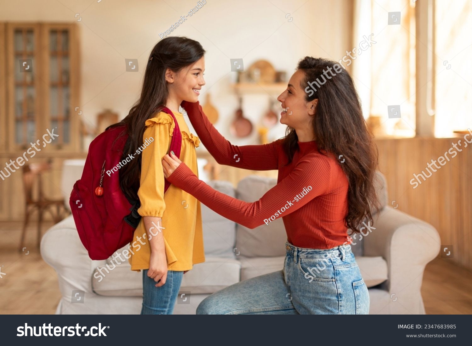 Back to School. Happy middle eastern mom preparing preteen schoolgirl daughter with backpack for first school day at home, looking at kid and encouraging her to enjoy classes in the morning #2347683985