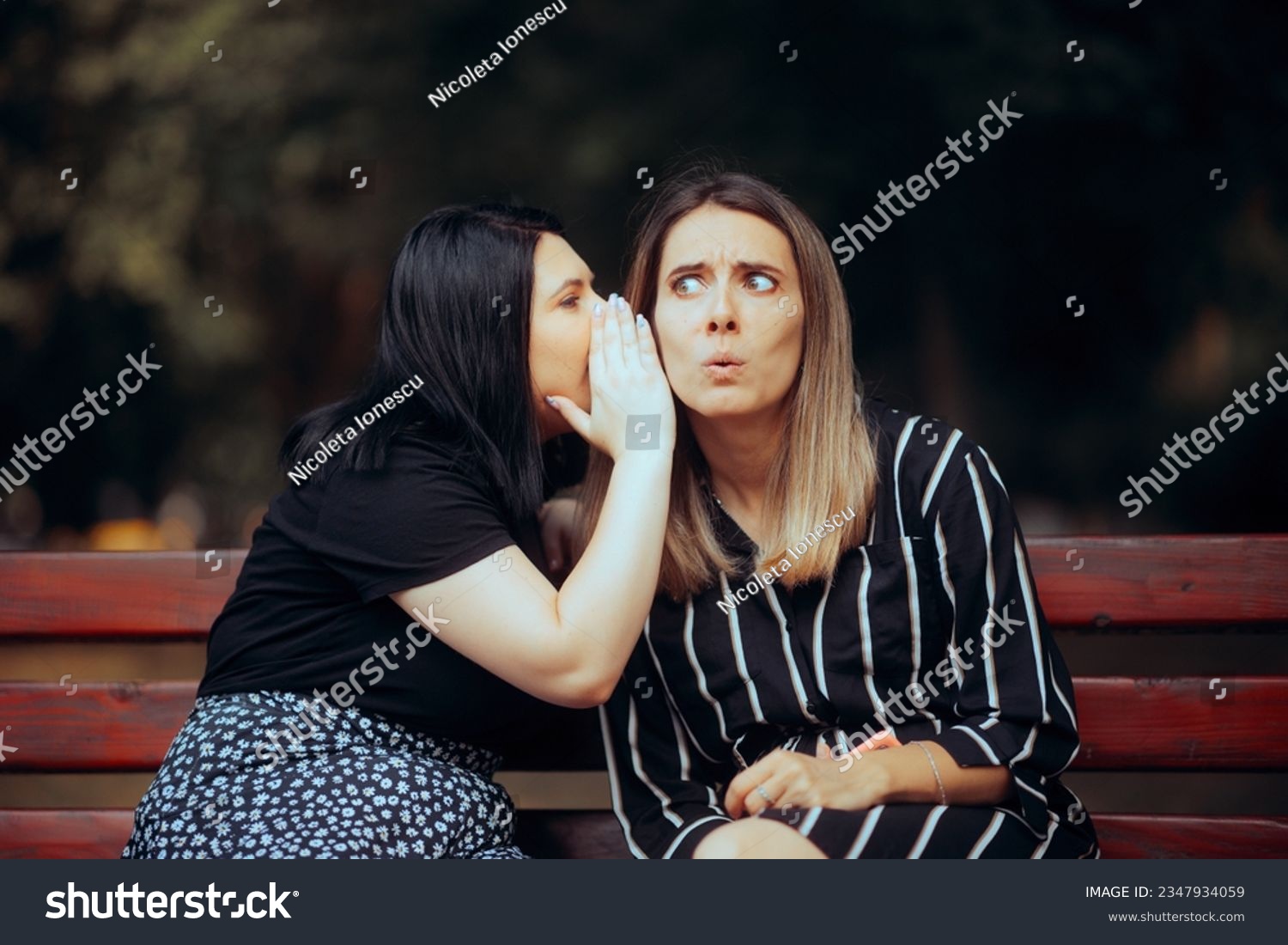 
Girl Whispering Rumors to her Curious Surprised Friend. Funny woman reacting to the gossip spread by her best friend 
 #2347934059