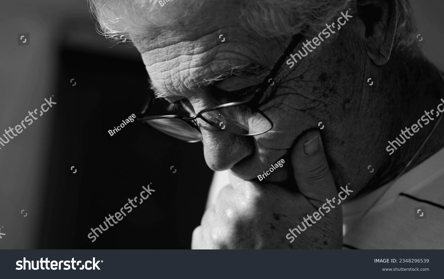 Senior man considering options in monochrome black and white. Dramatic elderly person ponders problems with hand in chin #2348296539