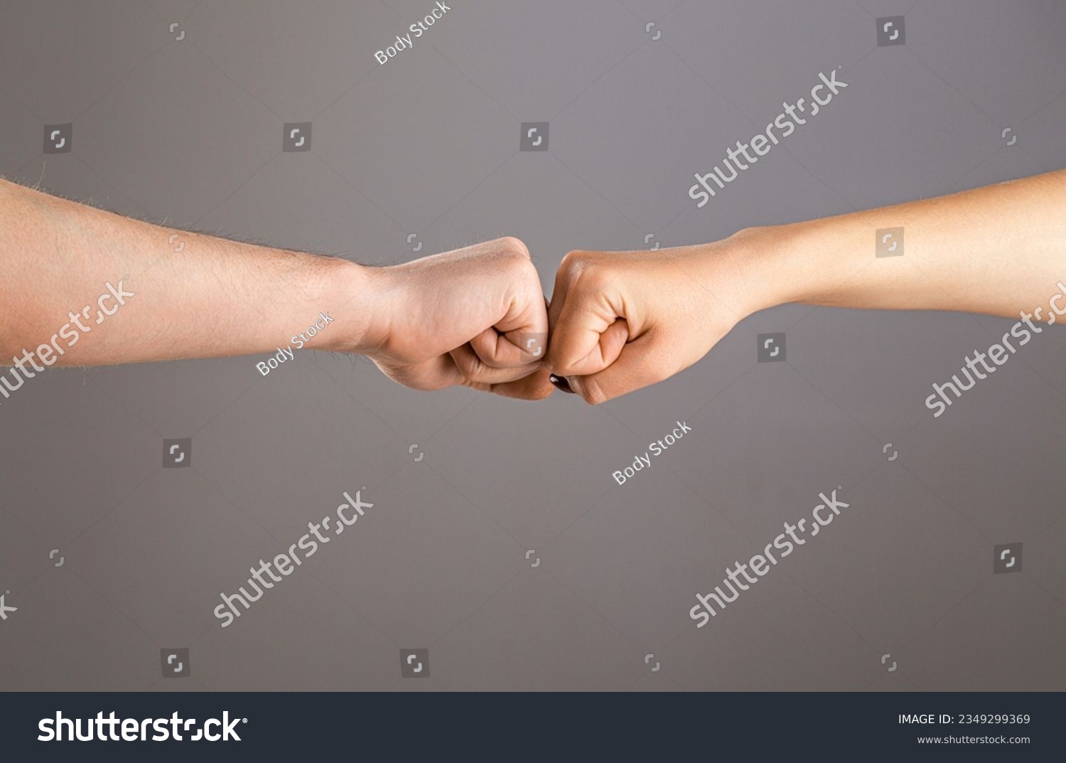 Man and woman are fist bumping. Fist Bump. Clash of two fists, vs. Gesture of giving respect or approval. Friends greeting. Teamwork and friendship. Partnership concept. Male vs female hand. #2349299369